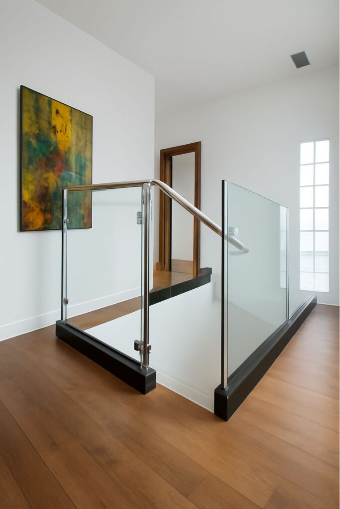 This image contains a staircase with glass railings